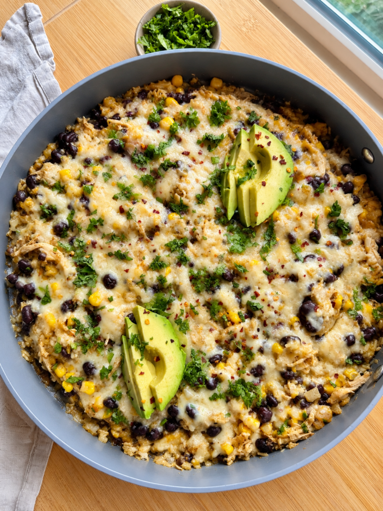 Finished salsa verde chicken and rice skillet garnished with cilantro and avocado