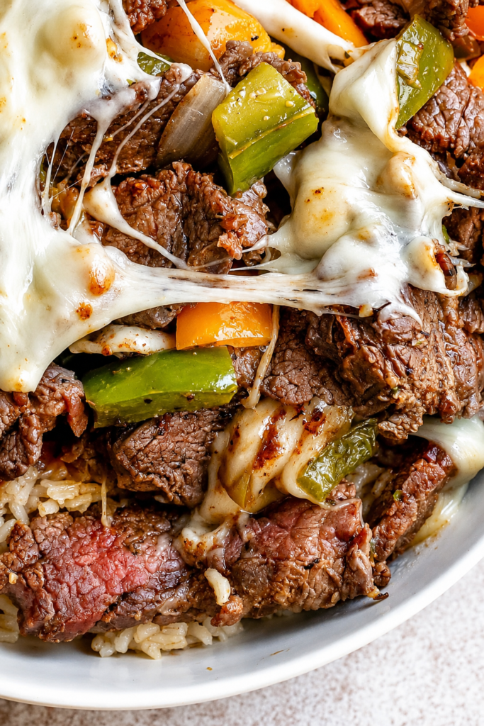 Philly cheesesteak bowl topped with melted provolone
