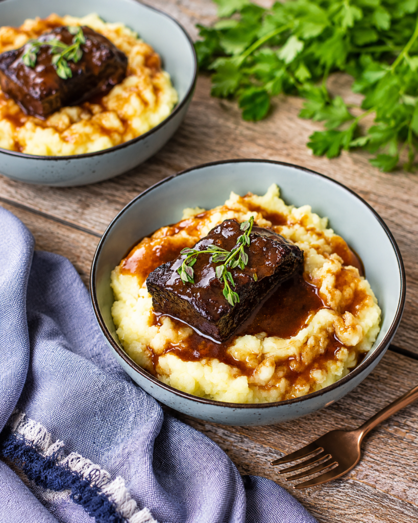 Short ribs braising in red wine sauce in a covered Dutch oven