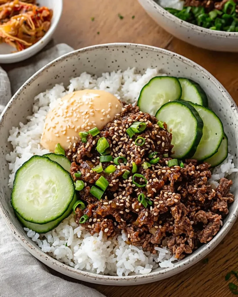 Ground beef browning with garlic and ginger in a skillet