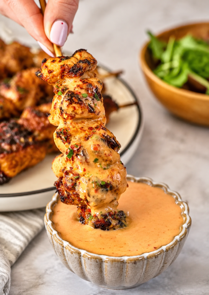 Finished bang bang chicken skewers garnished with parsley