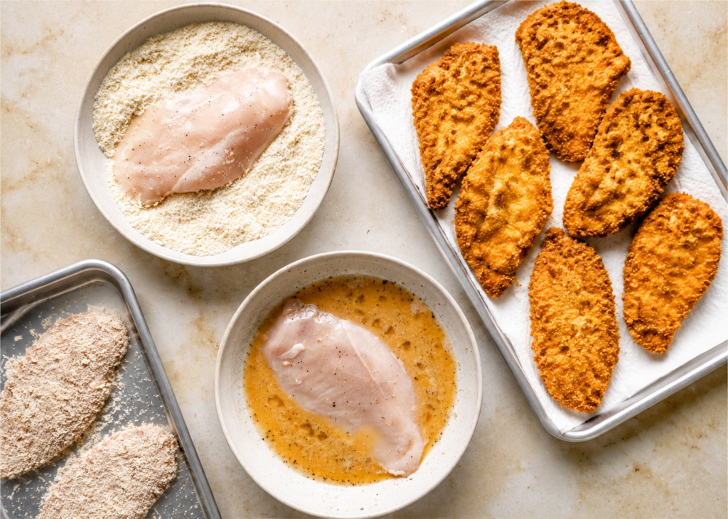 Chicken breasts being sliced into thin cutlets