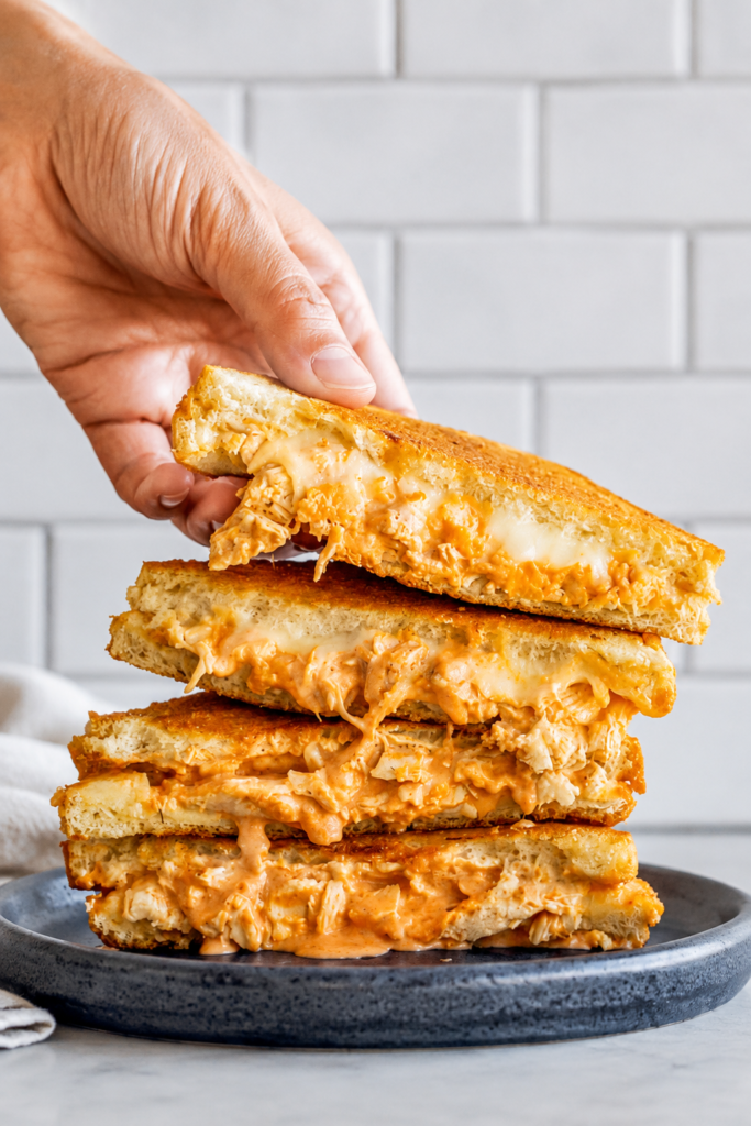 Buffalo chicken grilled cheese cooking golden in a skillet