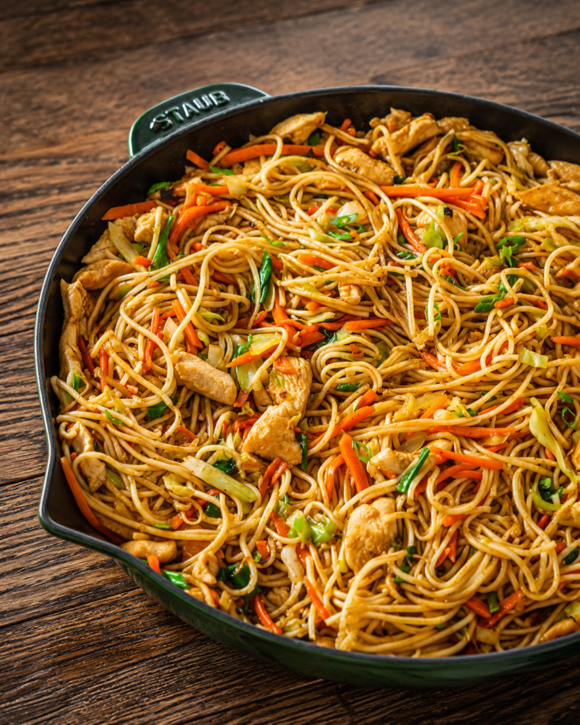 Noodles, chicken, and sauce combined in a wok