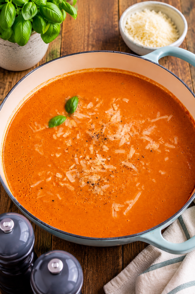 Finished high protein tomato soup garnished with parmesan and basil